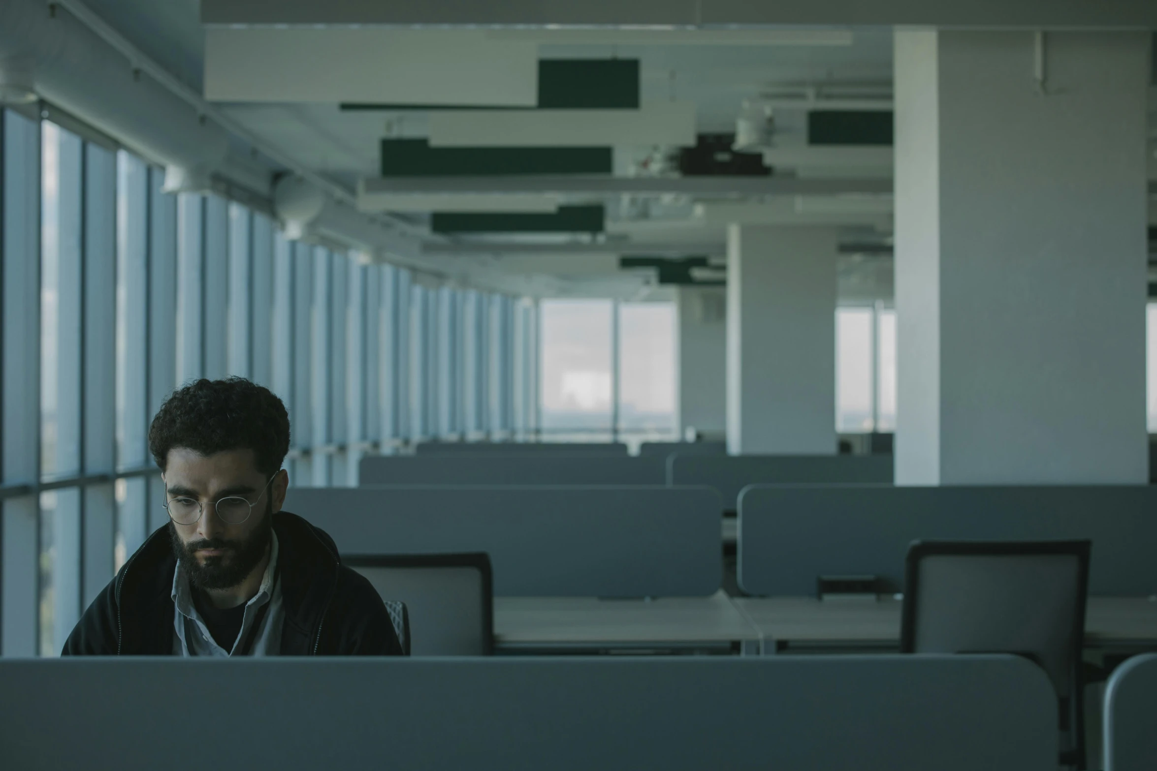 man behind desk of office building, looking at camera