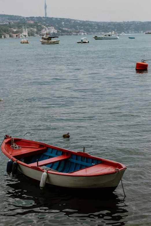 a boat floating on top of a lake with boats in the background