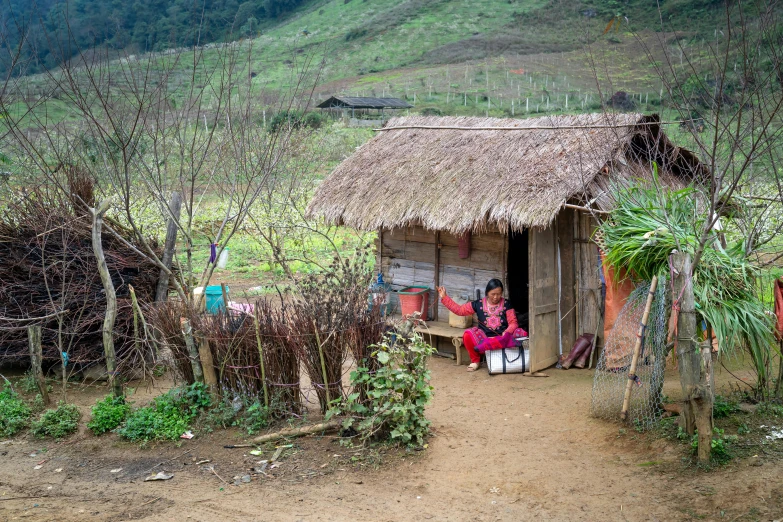 small hut with people inside and a mountain behind it