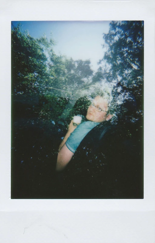 a man taking a picture of trees through the window