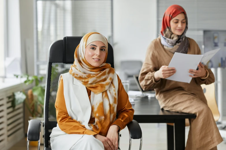 two young women sitting next to each other in a chair