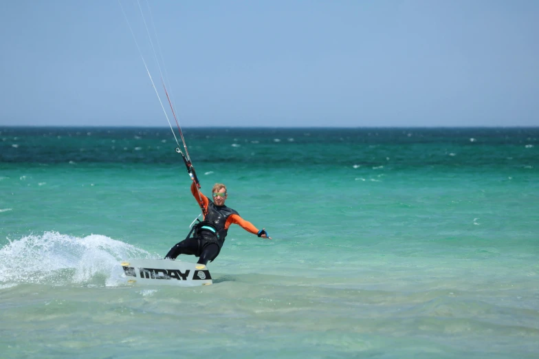 a man water skiing holding on to a rope with a kite