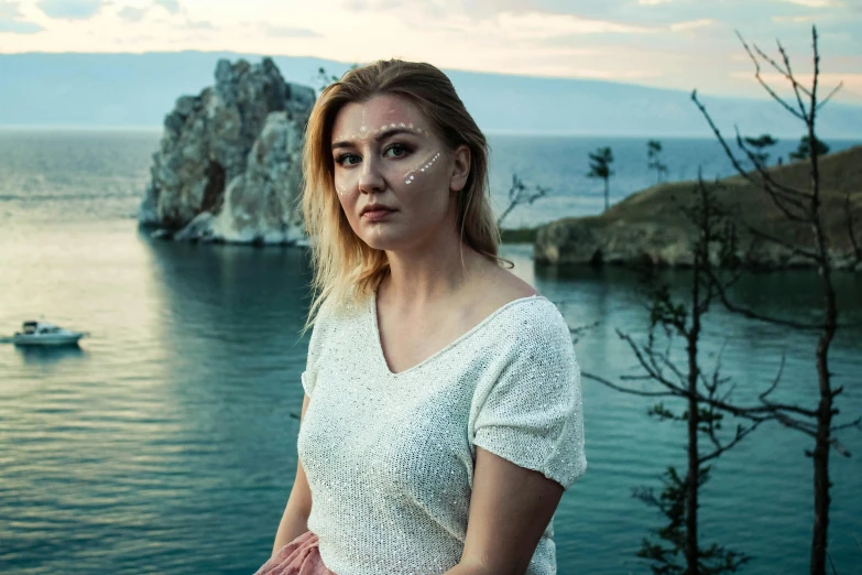 a woman wearing an eyeliner on the side of a cliff