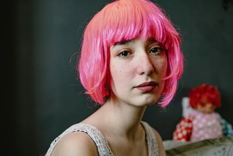 a girl with pink hair sitting on a couch