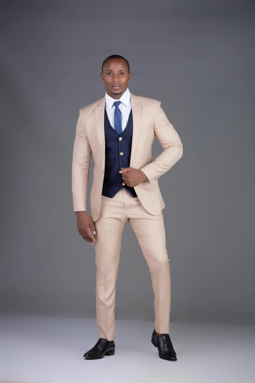 a man in a beige suit posing for the camera