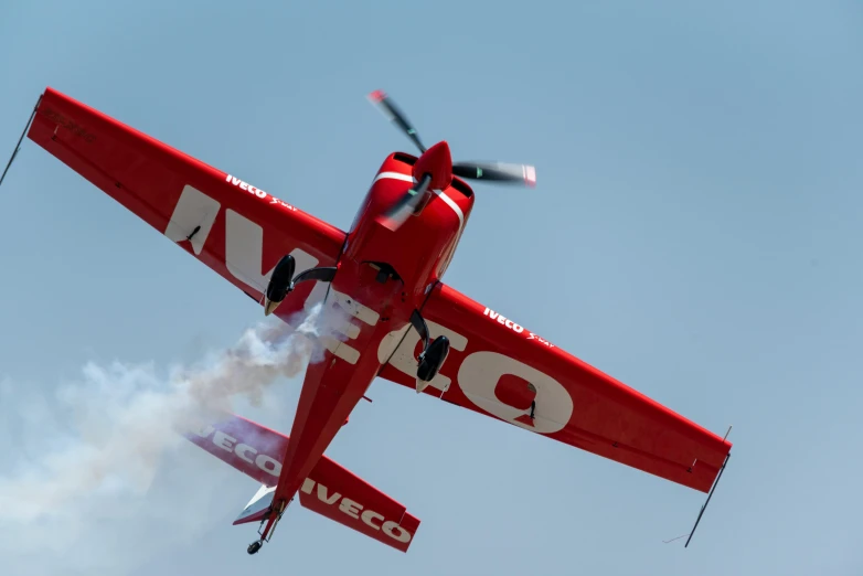 a small airplane with it's landing gear down as the smoke comes out