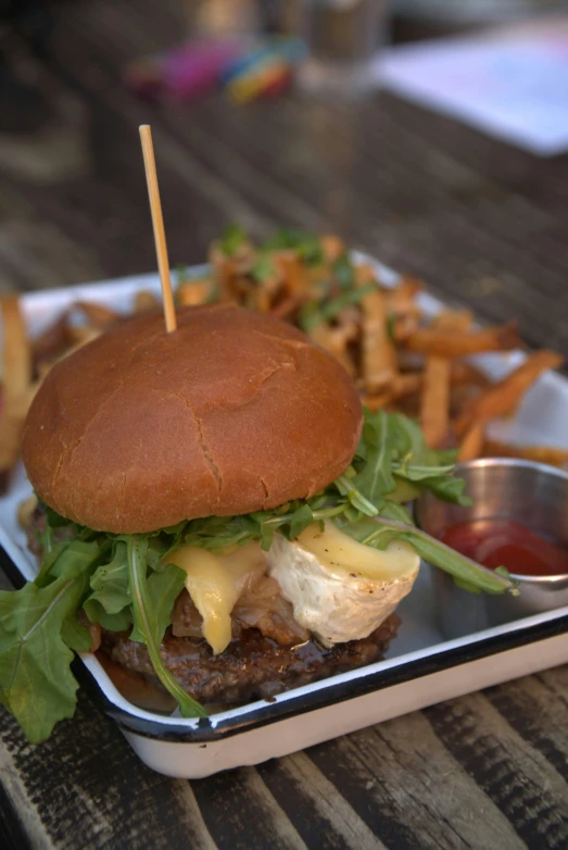 a tray topped with a burger and fries