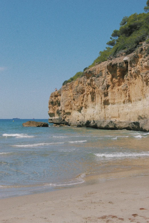 a beach and some water near the cliffs