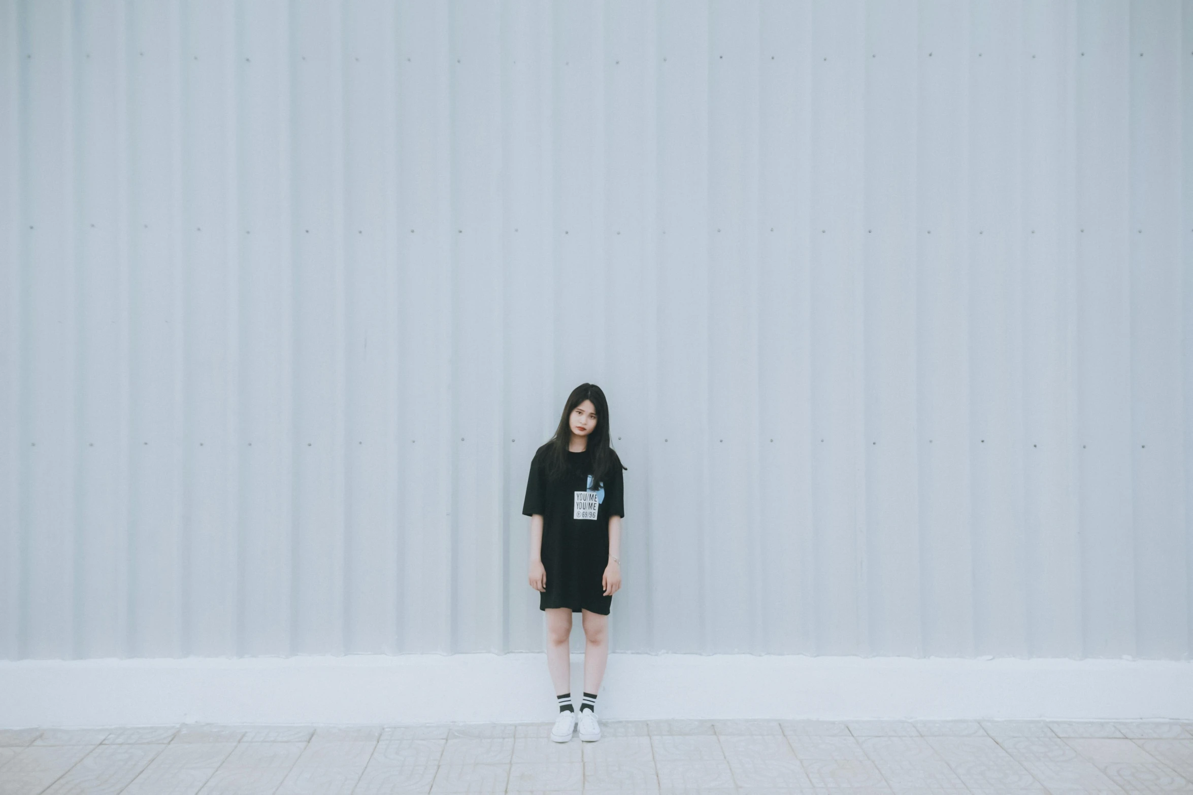 a woman is standing in front of a white building