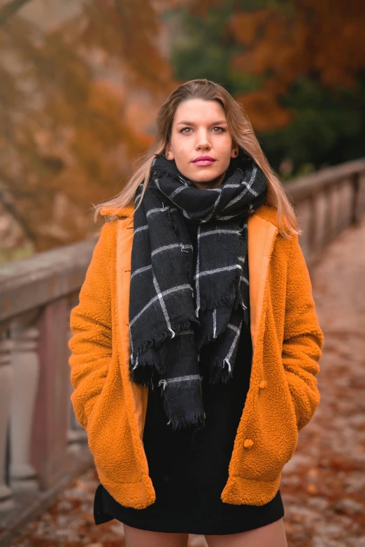 a woman standing next to some rocks in the fall