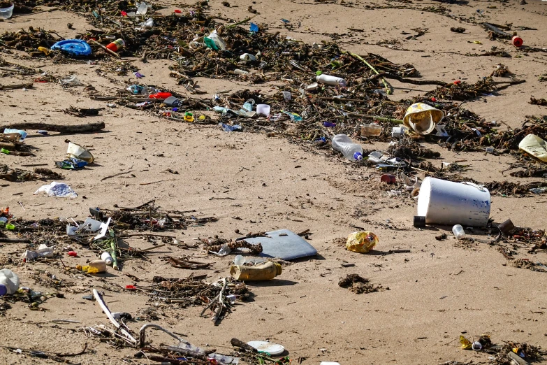 several containers, cans and garbage left on the beach