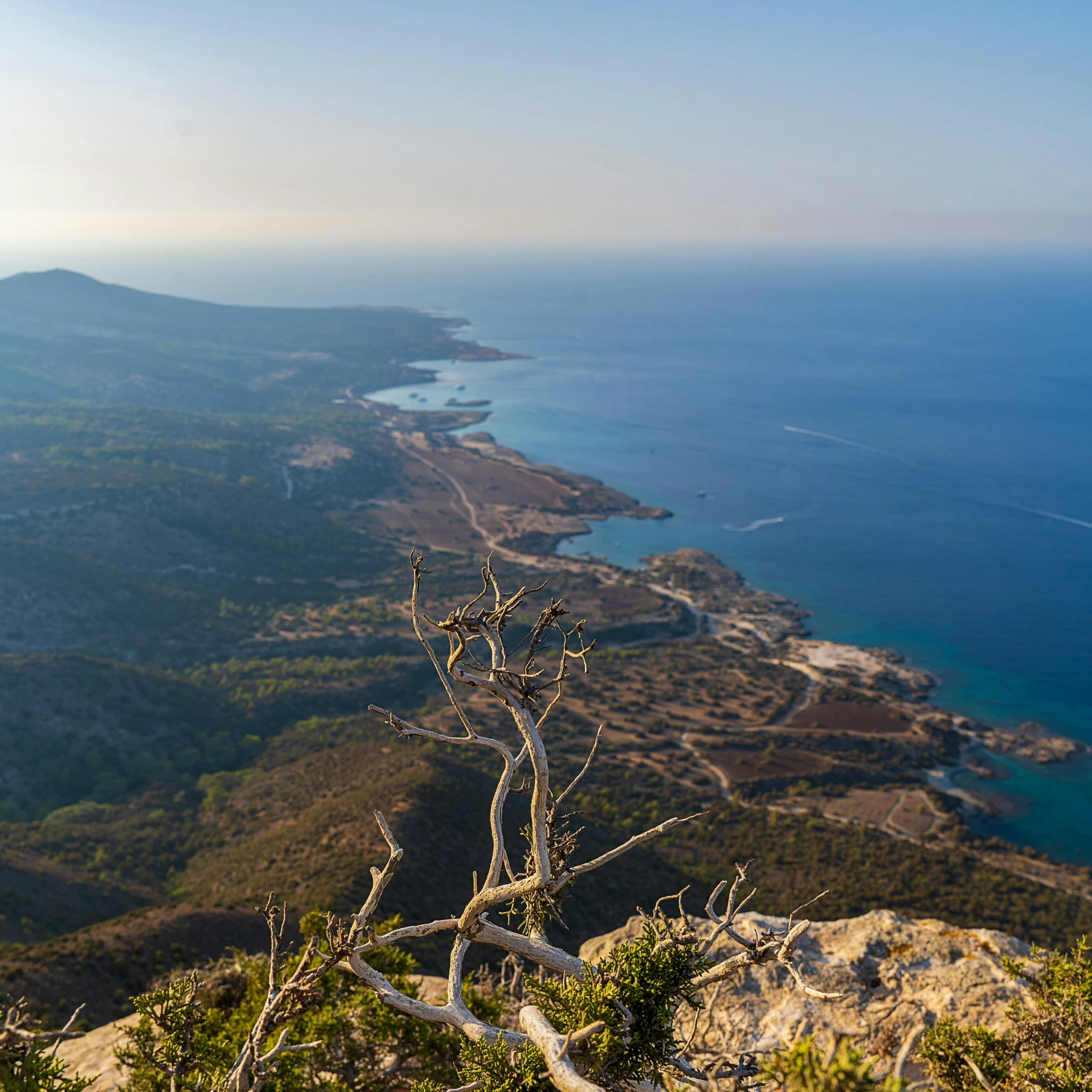 an outdoor bench on top of a mountain near the ocean