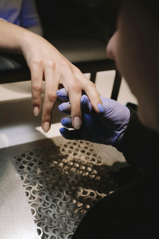 two hands are touching a metal counter top