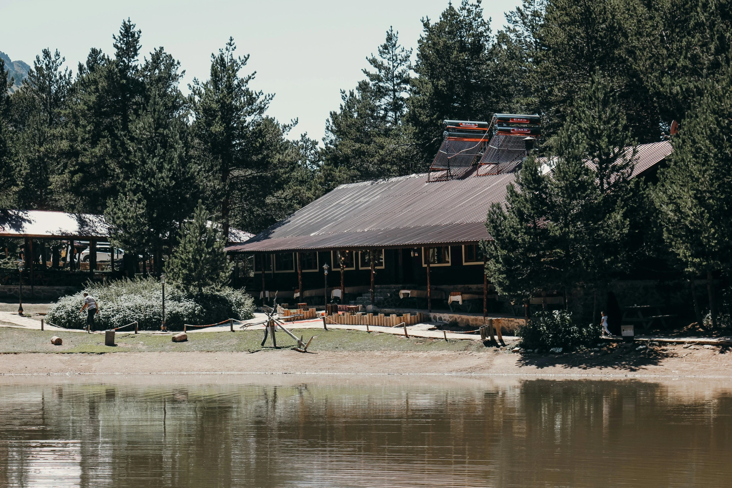 a large house sitting in the middle of trees next to water