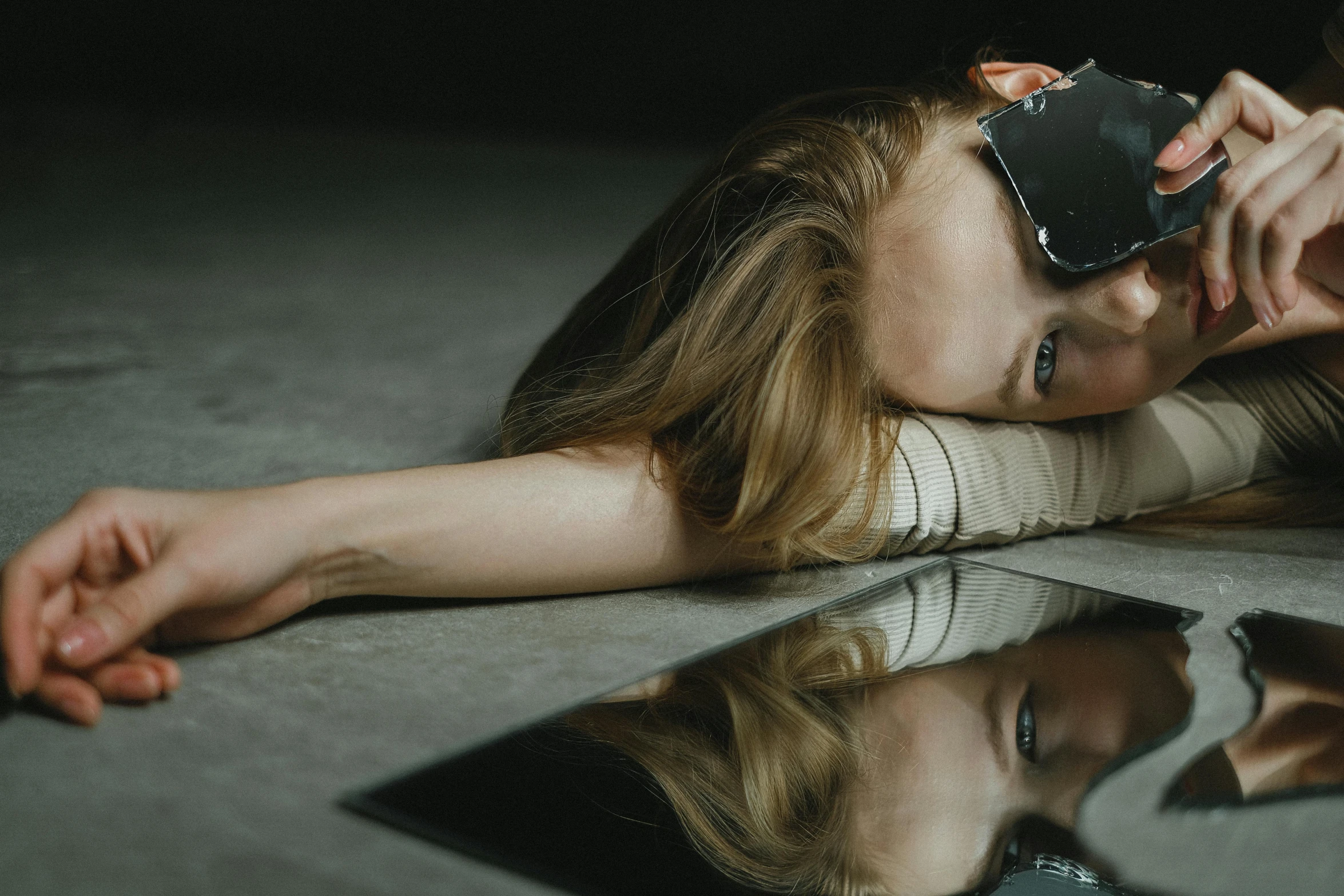 a woman lying on the floor with her head in her hands