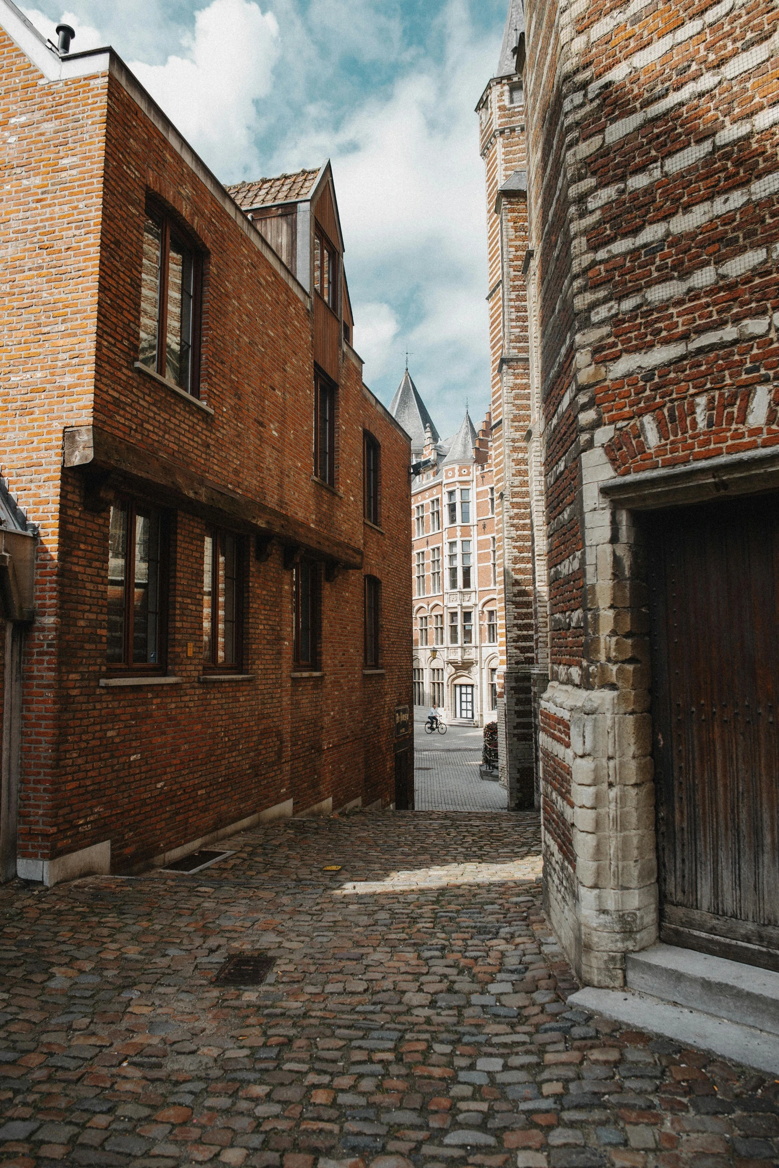 a narrow alley in a european city with red brick