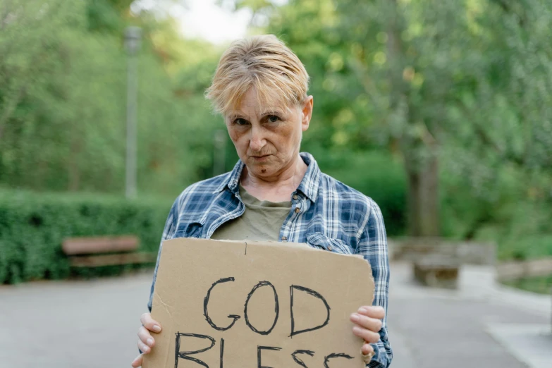 a person holding a sign that says god b'e bus