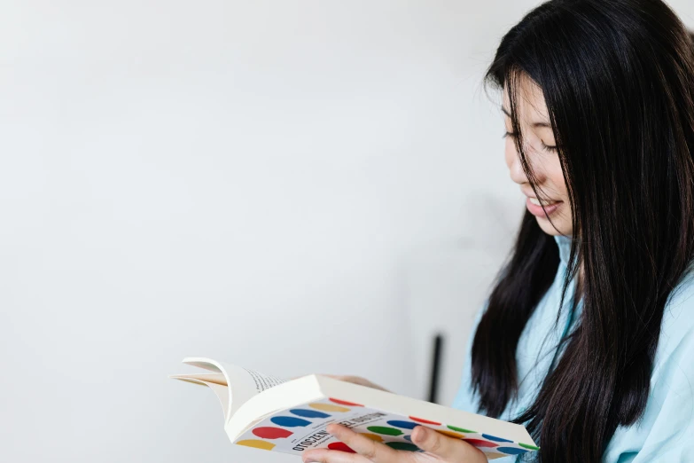 a girl looking at the book on her left arm