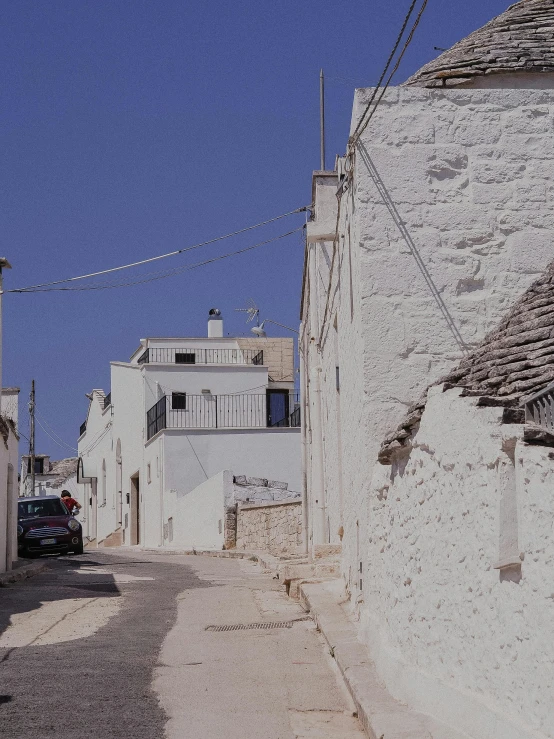 a small alley with a few cars parked between buildings