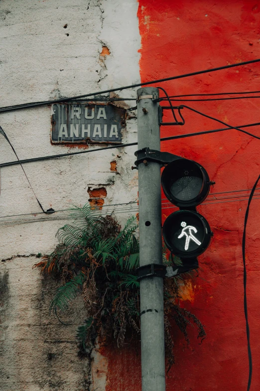 the stoplight has been changed on a rusty red wall