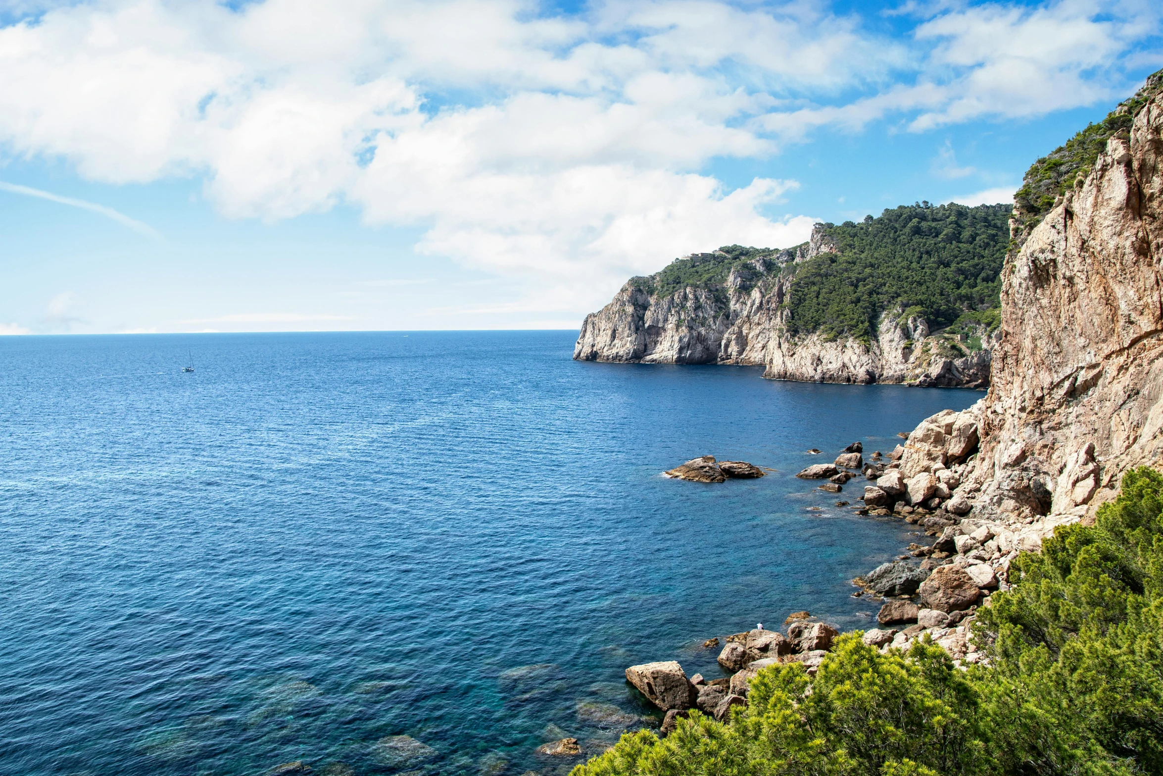 the cliffs overlooks a vast ocean, blue water and mountains