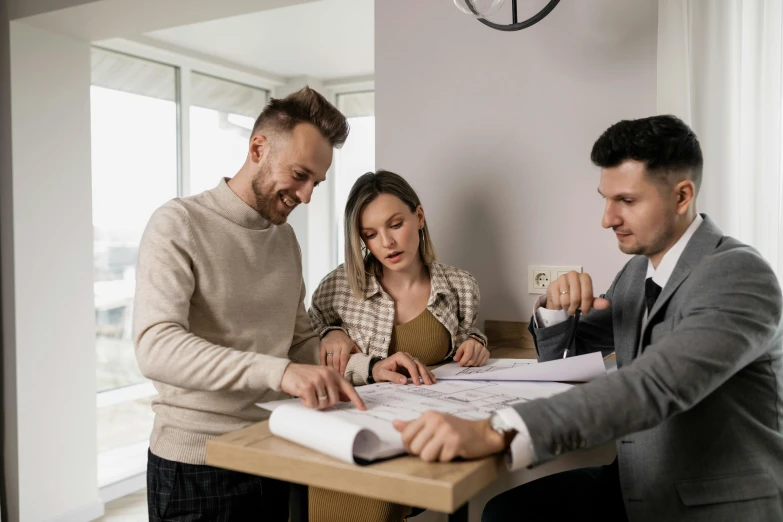 three men and a woman are doing architectural work