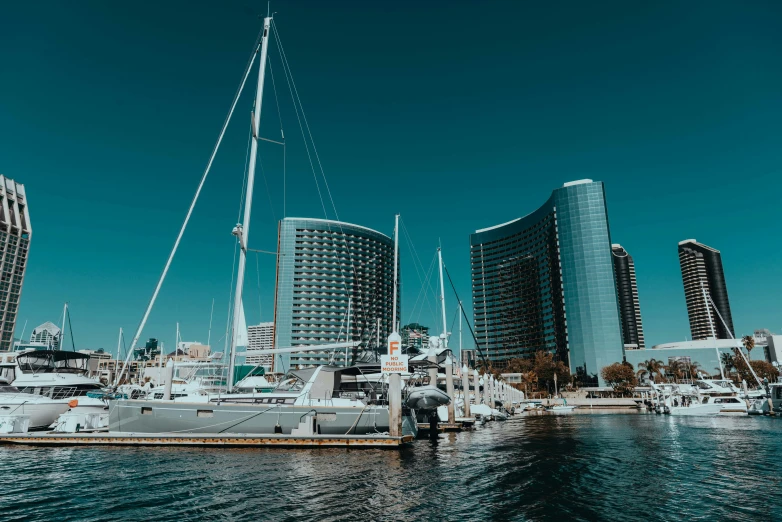 some boats are docked in the ocean near some tall buildings