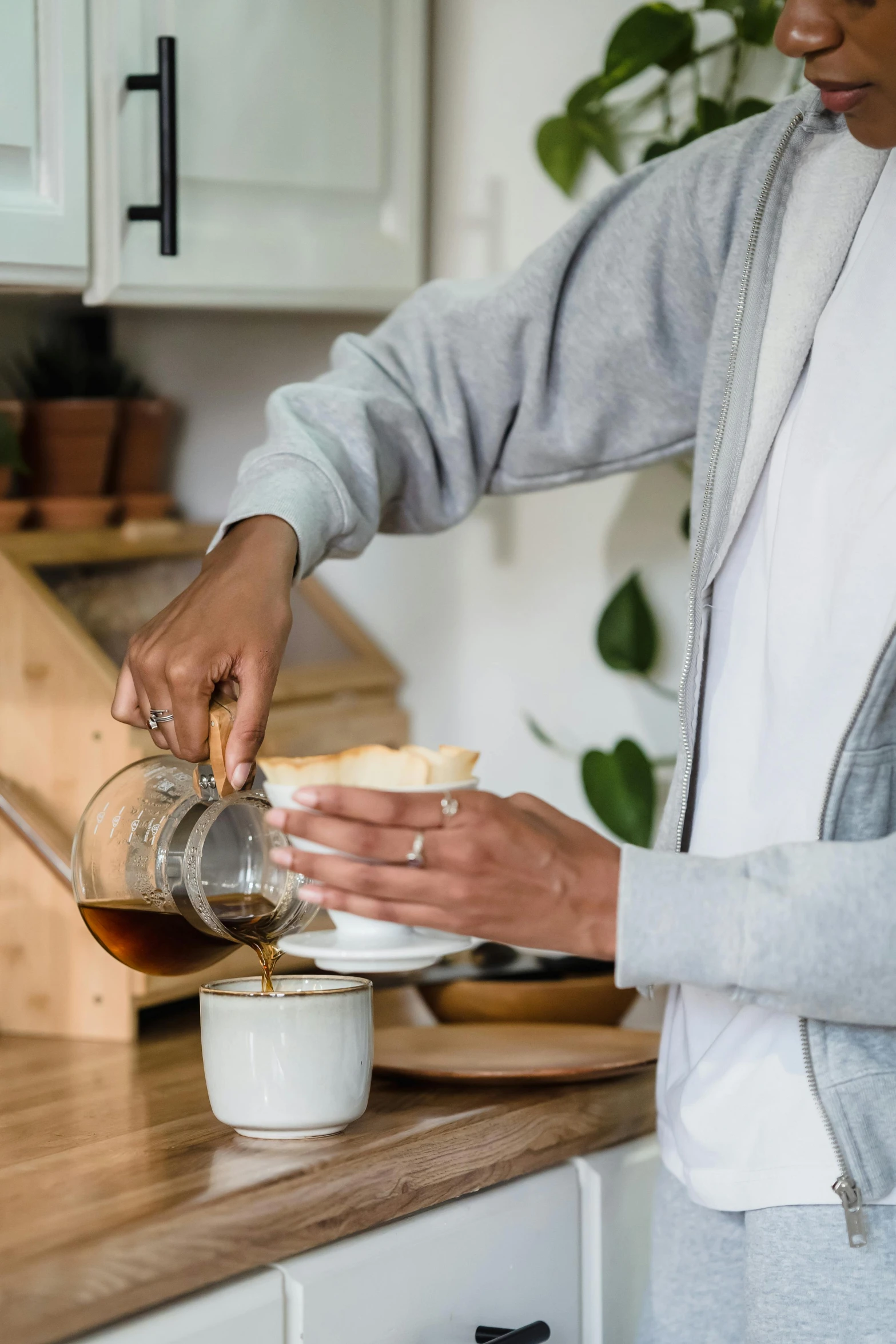 a man pouring soing into a cup in the kitchen