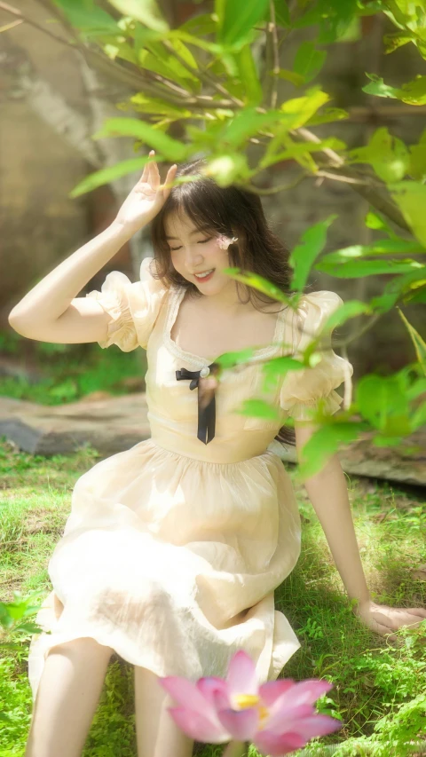 a woman sitting on a grass in a white dress