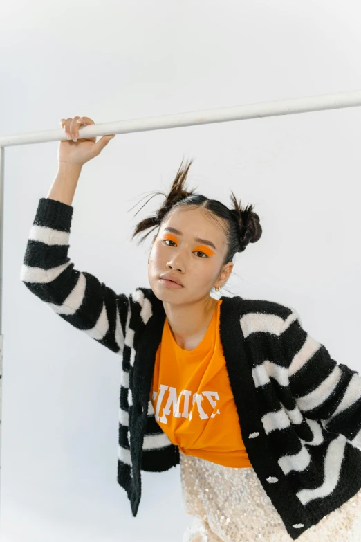 a woman posing for the camera while wearing orange makeup