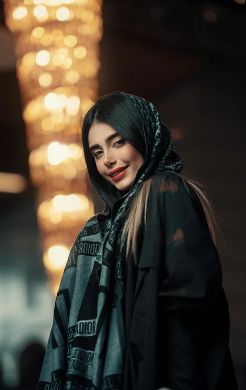 a woman in black jacket standing next to lights