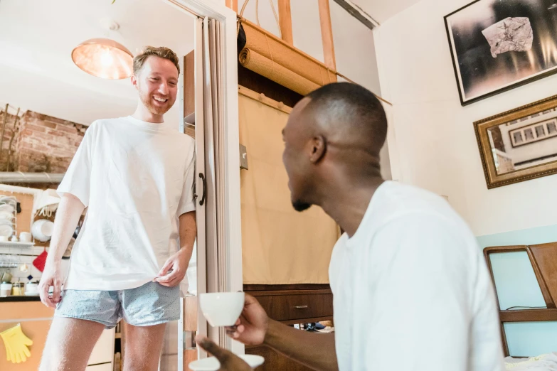 two men are standing near a door and laughing