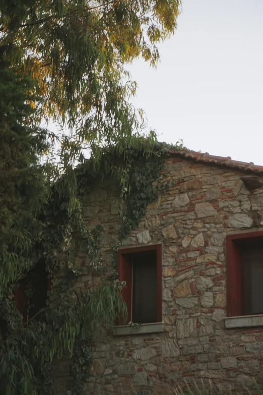 an old building with two windows and a bricked building