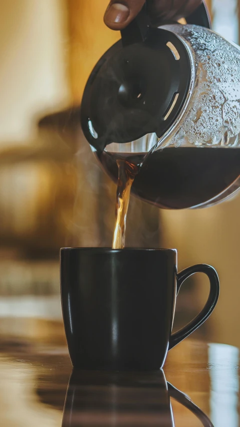 a close up of a cup of coffee pouring