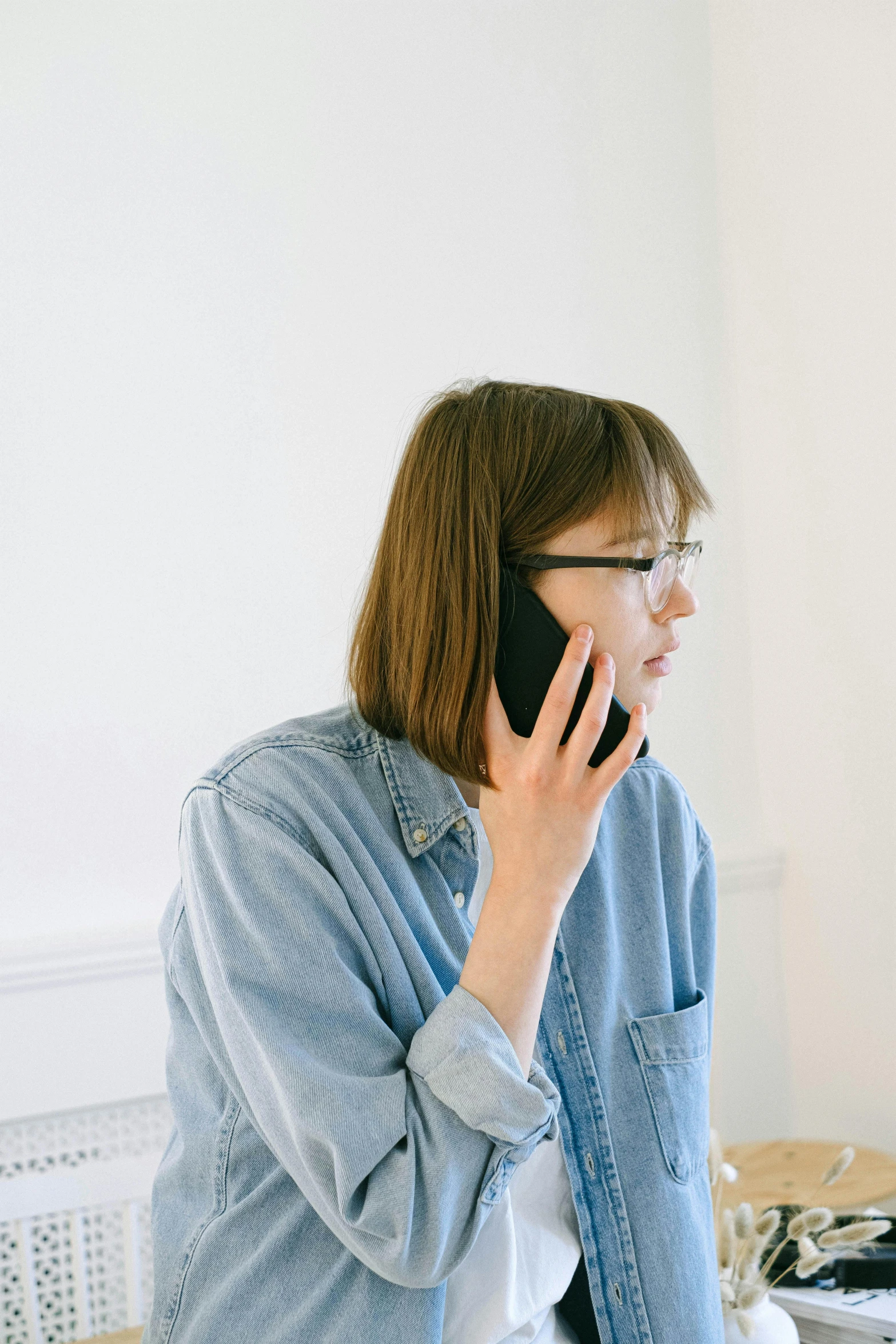 a person in glasses talking on their cellphone