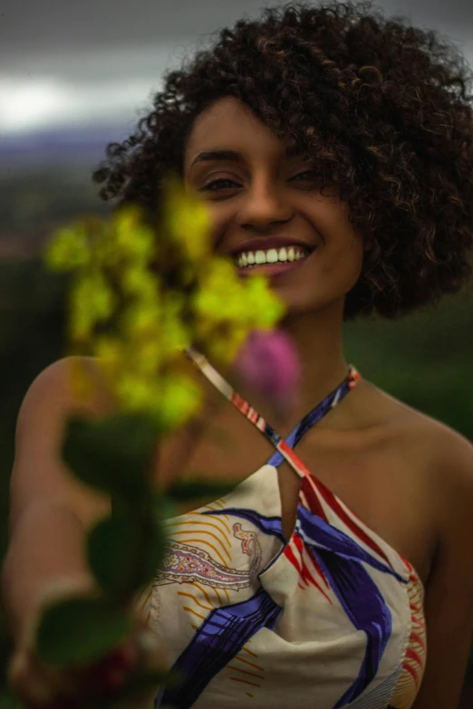 an image of a smiling girl that is holding a flower