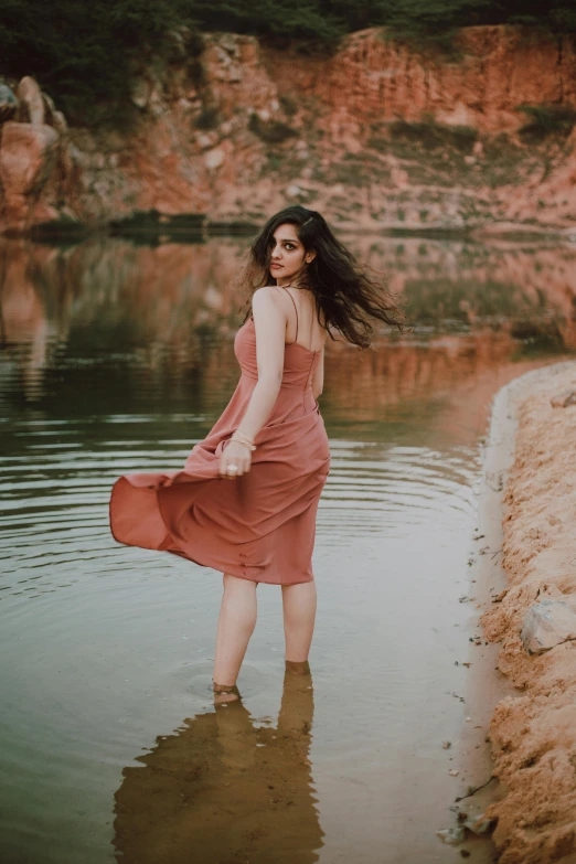 a woman in a brown dress standing in the water