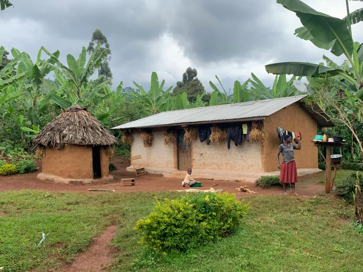 an african hut is shown with a couple of people