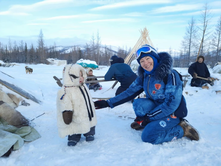 a man is sitting in the snow with two dogs