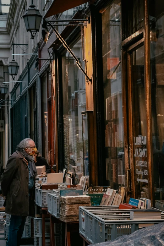 a man standing outside of a book shop