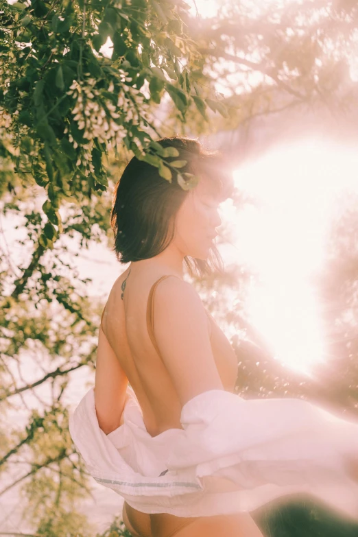 a women in a dress and sun shining behind