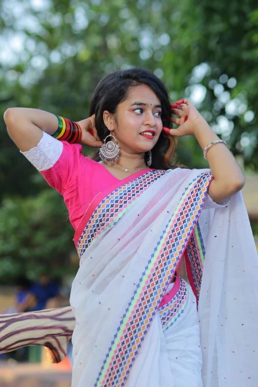 a beautiful young woman in a colorful white sari