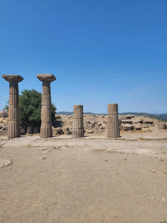 some stone pillars in the middle of a dirt field