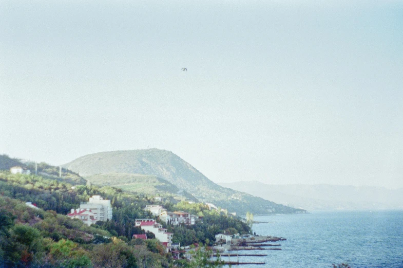 a large hill near the ocean with houses on it