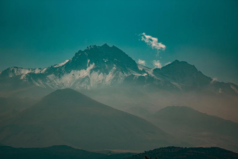 a snow covered mountain with trees in the foreground