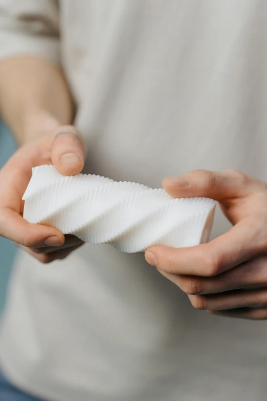 person holding small square of white substance in hands