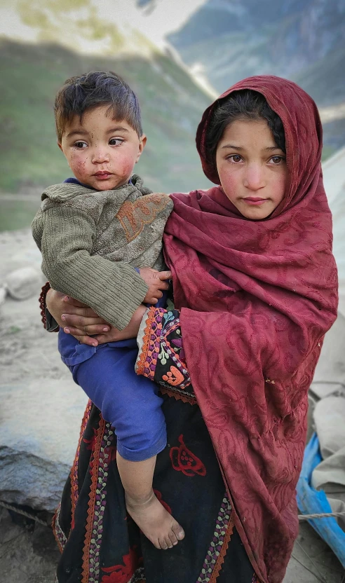 a girl holding her child next to her