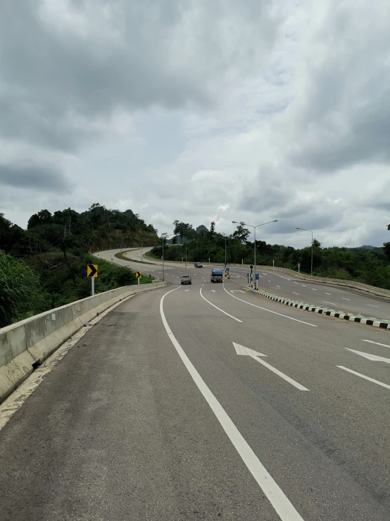 a view down an open highway where some cars are going