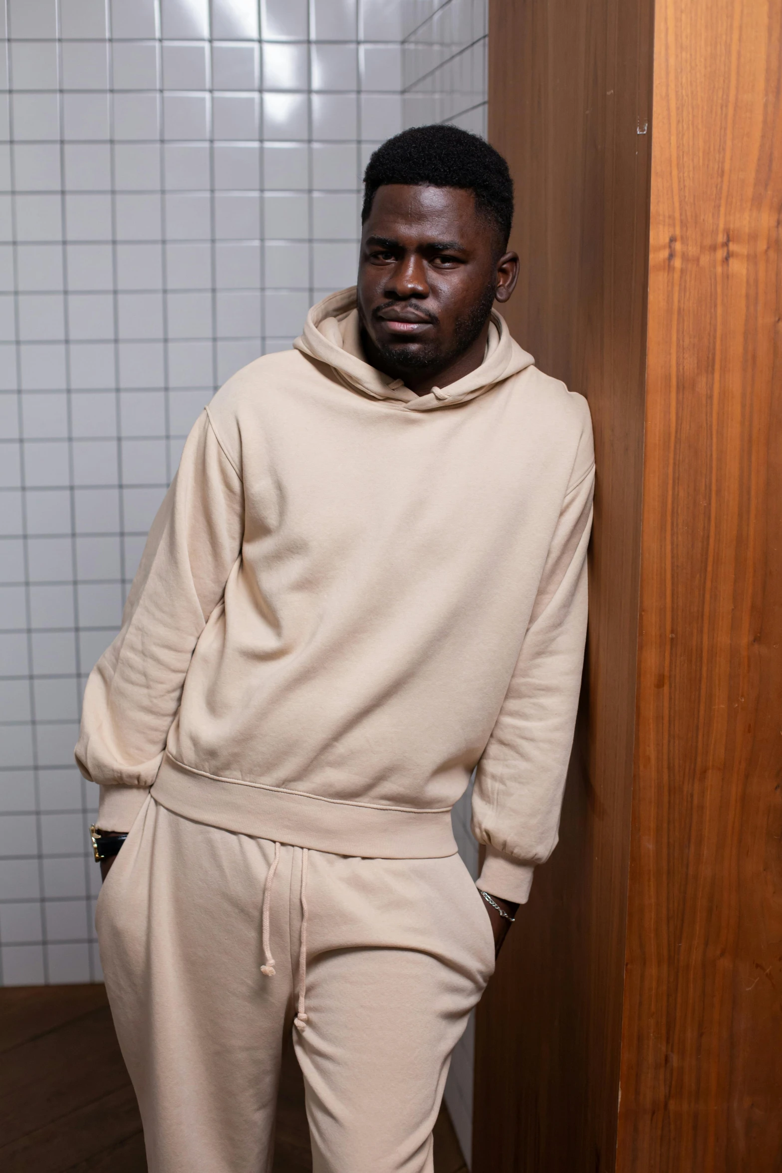 a black man in a sweater and sweat pants in a bathroom