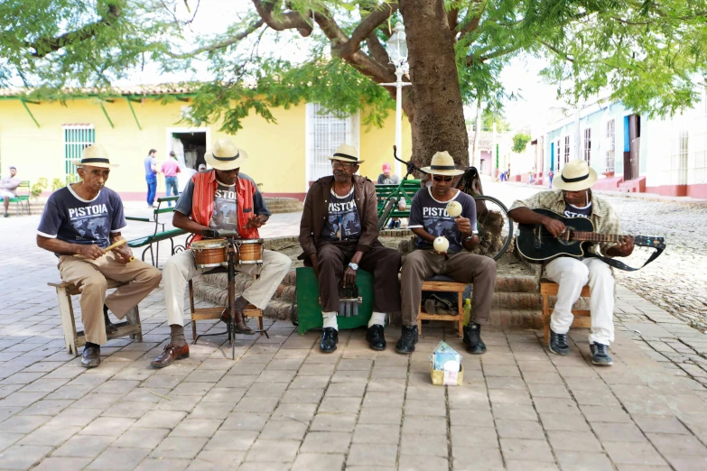 three men sitting and sitting under a tree